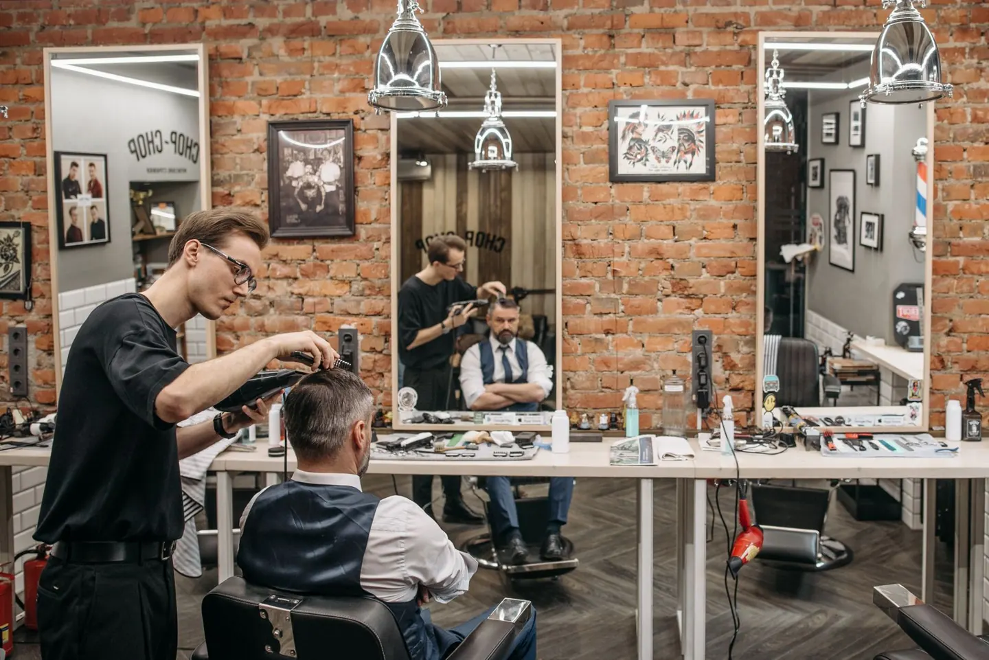 Barbier au travail dans un salon aux murs de brique